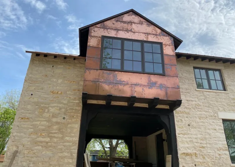 Copper metal panel facade on a stone building for Skylight Installation in Evans
