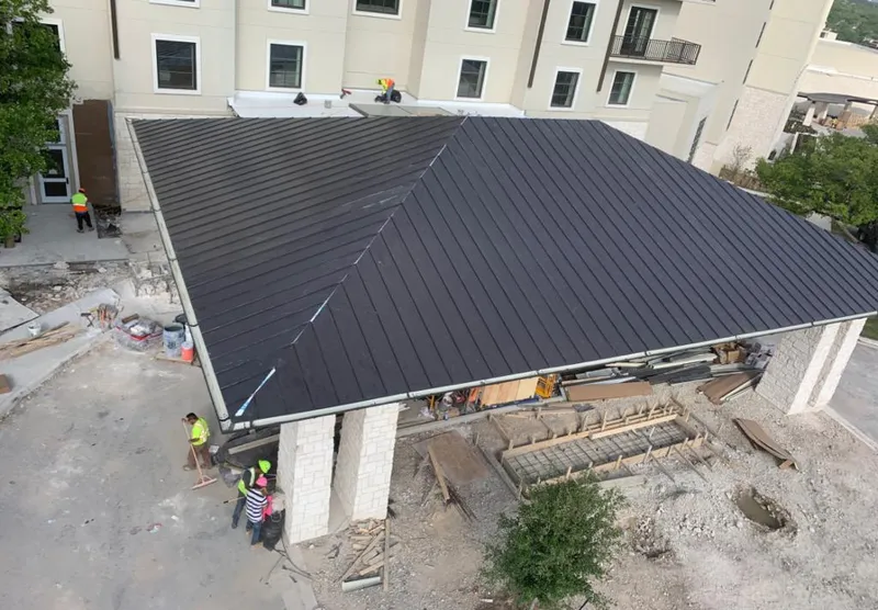 Metal roofing installation team working on a commercial building in Evans